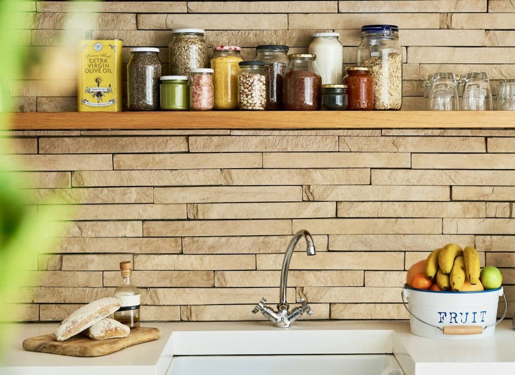 Organized kitchen shelf with pantry staples like olive oil, grains, and nuts, ideal for plant-based recipes sourced from Thrive Market