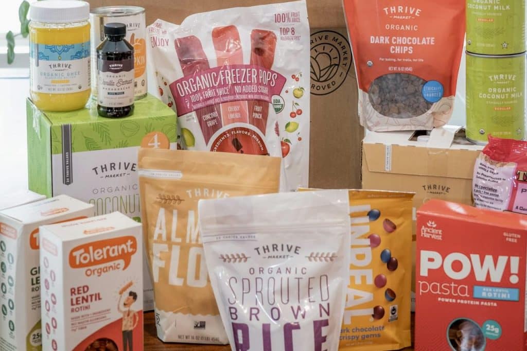 Thrive Market organic grocery items including almond flour, sprouted brown rice, red lentil pasta, and eco-friendly packaging for healthy, plant-based living