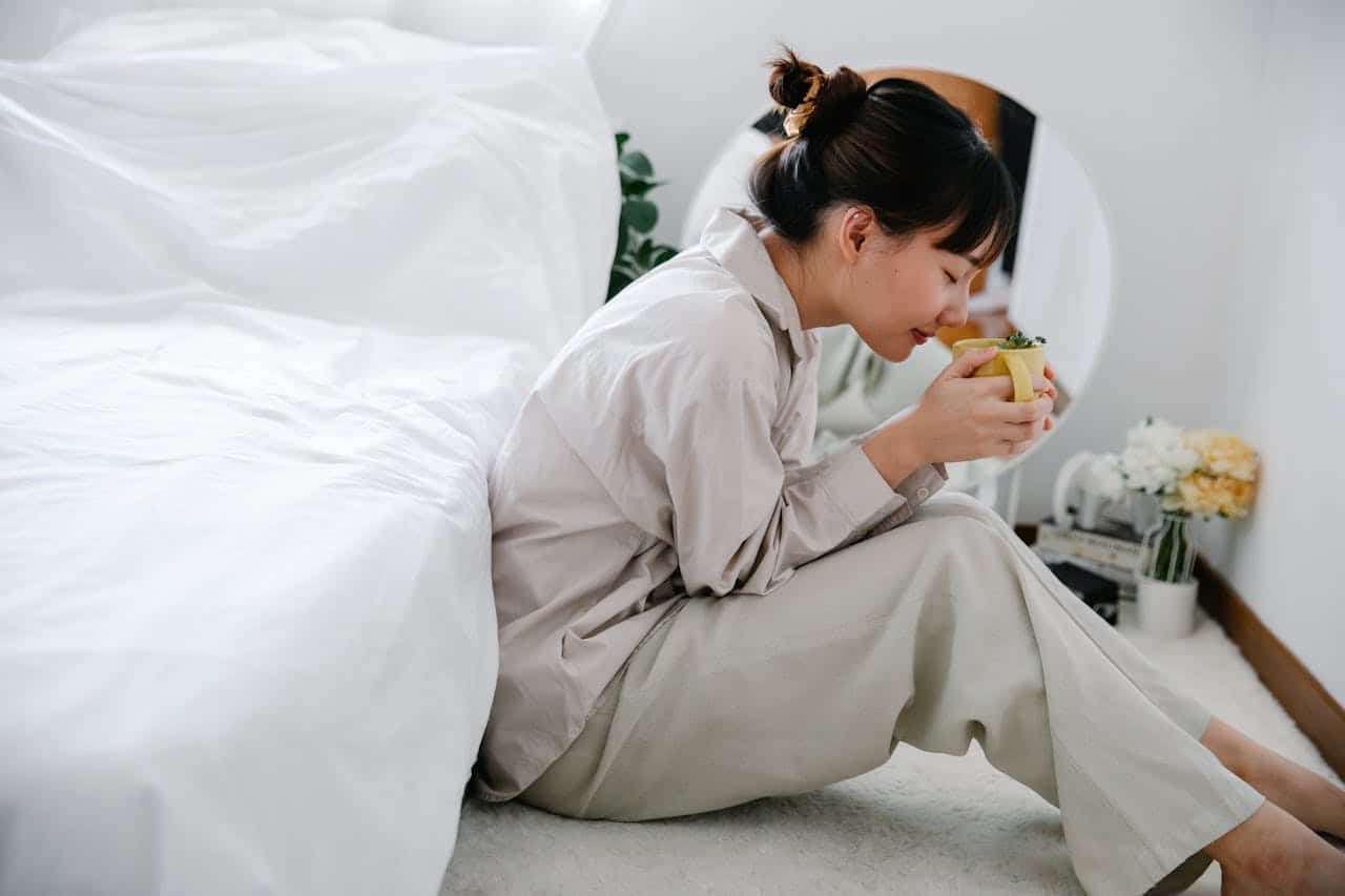 Mindful eating practice: woman in comfortable clothing practicing mindfulness while savoring a warm drink, demonstrating how to incorporate meditation into daily activities