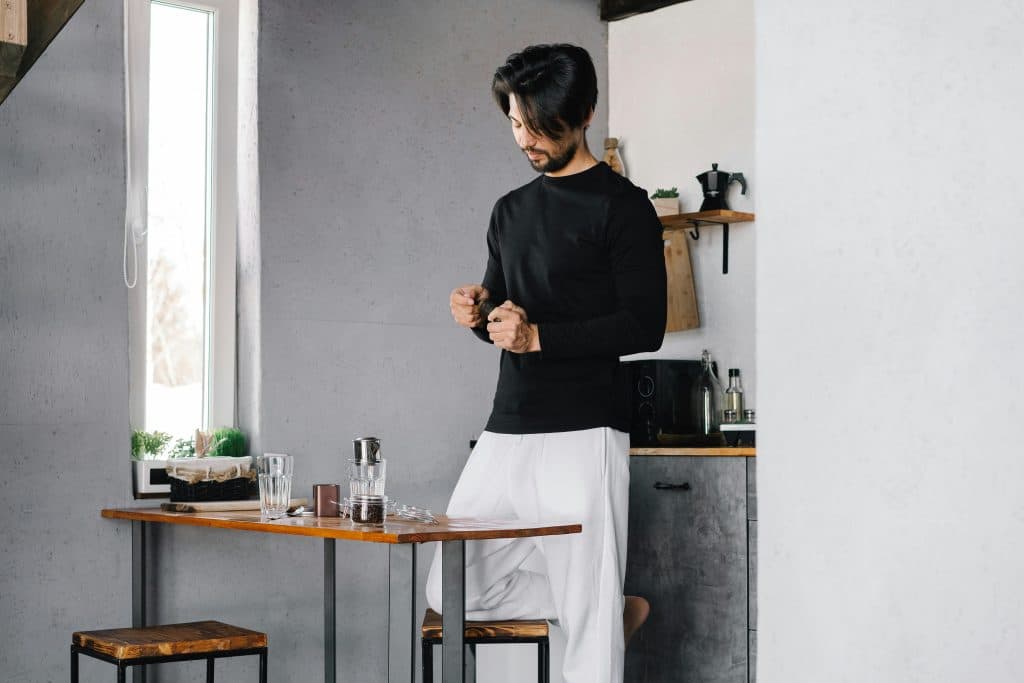 Man in minimal setting practicing mindfulness before meal, demonstrating peaceful mealtime routine and intentional eating habits