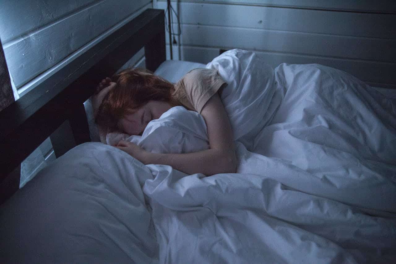 A person peacefully sleeping in a cozy bed at night, illustrating the importance of quality sleep for longevity and overall health