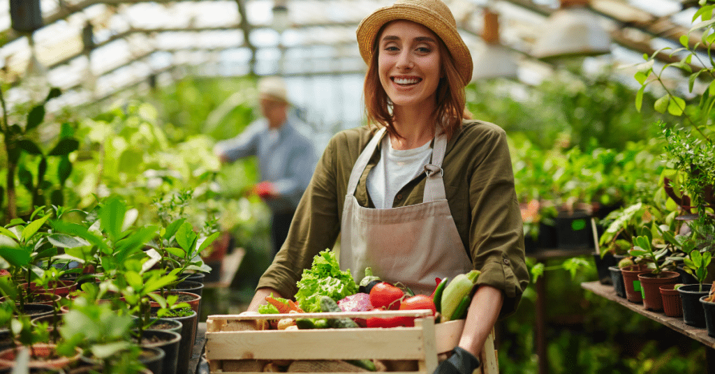 Smiling woman in greenhouse holding fresh vegetables, demonstrating sustainable and healthy lifestyle choices for optimal aging