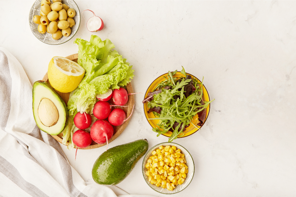 A vibrant plant-based meal featuring avocado, leafy greens, olives, and radishes—key foods in the Blue Zone diet that promote longevity and overall health.