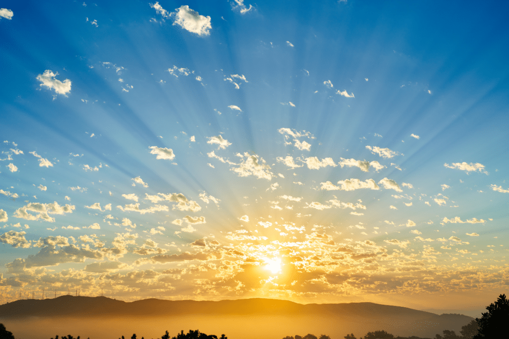 A golden sunrise over the mountains, symbolizing the natural sleep-wake cycle practiced in Blue Zones, promoting longevity through circadian rhythm alignment and restful sleep.