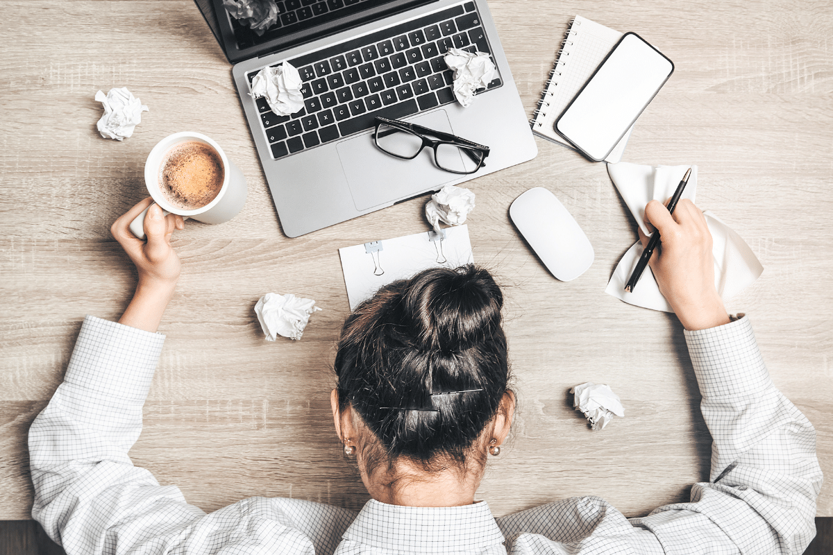 person burned out and exhausted at desk. Representative of todays hustle culture.